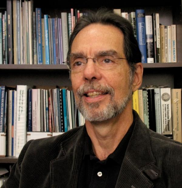 Joe Cone in front of a bookshelf