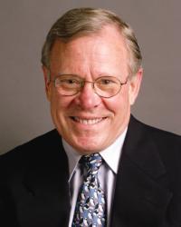 Jerry Schubel in front of a gray background