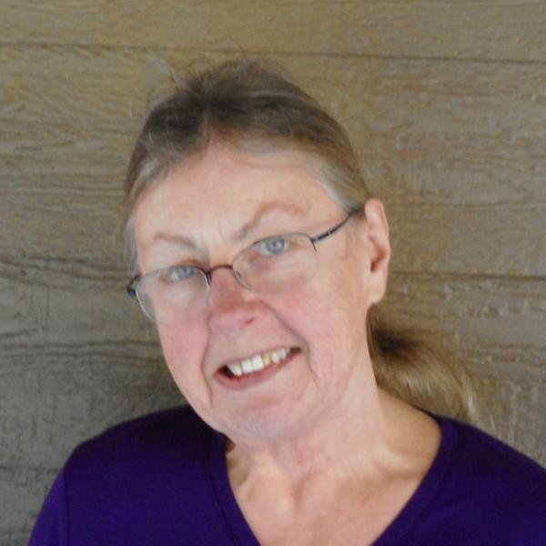 Susanna Priest in front of wood paneled background